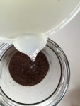 pour ground coffee and water into a jar